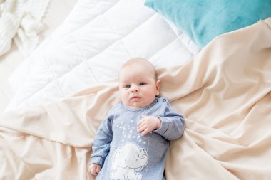 Küçük sevimli bebek yatakta evde yatıyor. Mutlu çocukluk