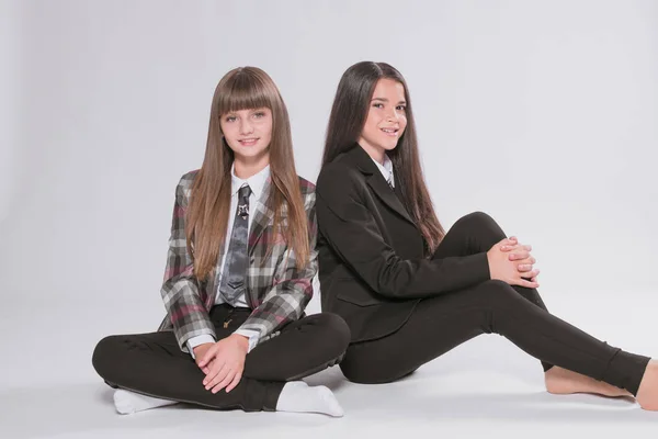 Twee Leuke Meisjes Schoolmeisjes Een Trendy Schooluniform Een Witte Achtergrond — Stockfoto