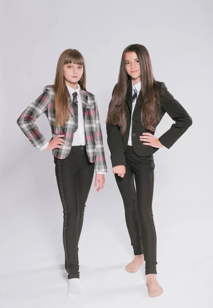 Twee Leuke Meisjes Schoolmeisjes Een Trendy Schooluniform Een Witte Achtergrond — Stockfoto