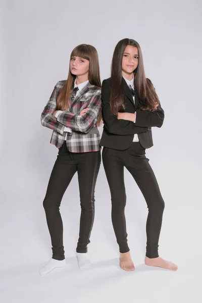 Twee Leuke Meisjes Schoolmeisjes Een Trendy Schooluniform Een Witte Achtergrond — Stockfoto