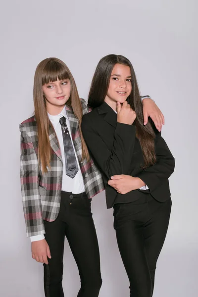 Twee Leuke Meisjes Schoolmeisjes Een Trendy Schooluniform Een Witte Achtergrond — Stockfoto