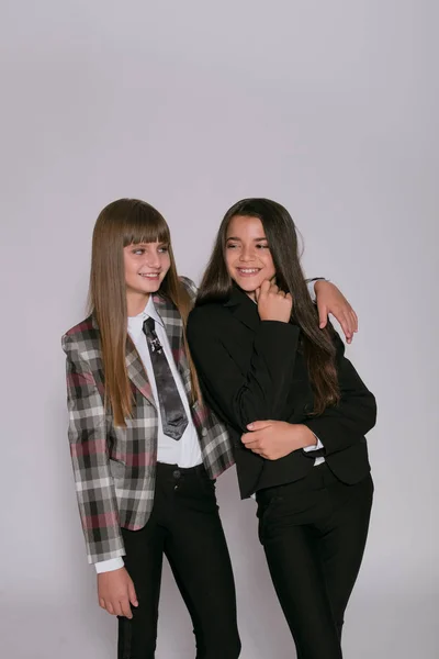 Twee Leuke Meisjes Schoolmeisjes Een Trendy Schooluniform Een Witte Achtergrond — Stockfoto