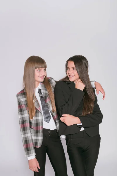 Twee Leuke Meisjes Schoolmeisjes Een Trendy Schooluniform Een Witte Achtergrond — Stockfoto