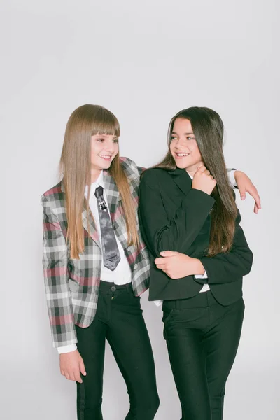 Twee Leuke Meisjes Schoolmeisjes Een Trendy Schooluniform Een Witte Achtergrond — Stockfoto