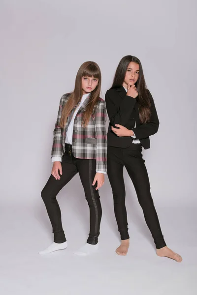 Twee Leuke Meisjes Schoolmeisjes Een Trendy Schooluniform Een Witte Achtergrond — Stockfoto