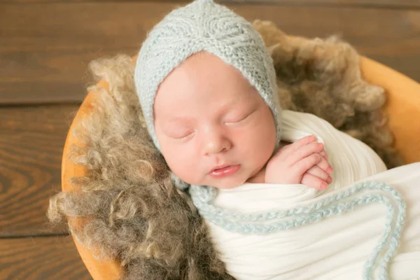 Schattige Pasgeboren Baby Een Blauwe Gebreide Muts Een Houten Mand — Stockfoto