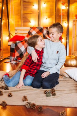 Uzun saçlı sevimli küçük kız kardeşi ve kabak ve plaids ile sonbahar sahne bir ağabey stüdyoda oynamak