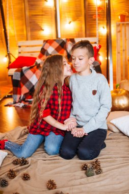 Uzun saçlı sevimli küçük kız kardeşi ve kabak ve plaids ile sonbahar sahne bir ağabey stüdyoda oynamak