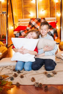 Uzun saçlı sevimli küçük kız kardeşi ve kabak ve plaids ile sonbahar sahne bir ağabey stüdyoda oynamak