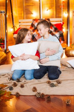 Uzun saçlı sevimli küçük kız kardeşi ve kabak ve plaids ile sonbahar sahne bir ağabey stüdyoda oynamak