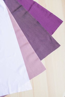 Ahşap arka planda parlak renkli kumaş kesikleri. Dikiş için kumaşlar. Dikiş malzemeleri