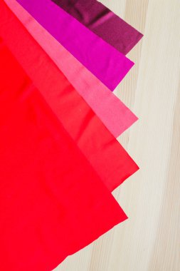 Ahşap arka planda parlak renkli kumaş kesikleri. Dikiş için kumaşlar. Dikiş malzemeleri