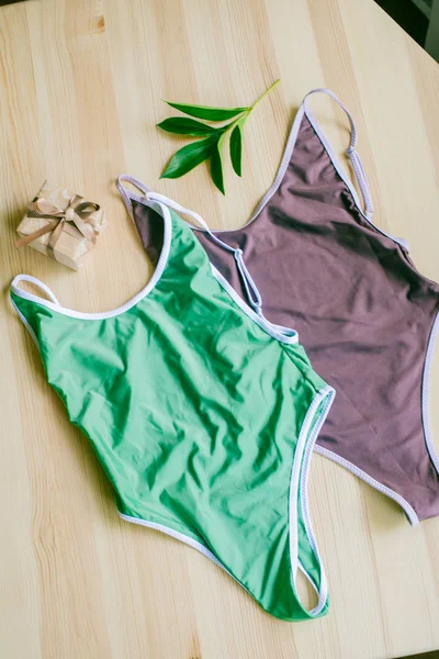 色彩艳丽的比基尼 木制背景 热带绿叶 时髦的泳衣 — 图库照片