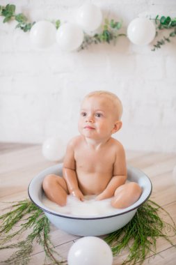 Tatlı küçük çocuk sabunlu su ve sabun köpüğüyle havuza su sıçratıyor. Sağlıklı çocukluk