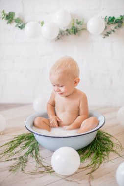 Tatlı küçük çocuk sabunlu su ve sabun köpüğüyle havuza su sıçratıyor. Sağlıklı çocukluk