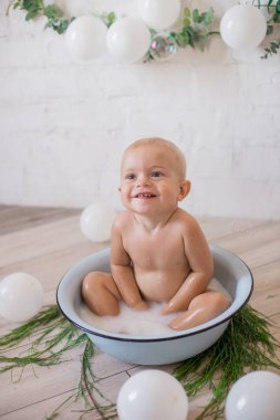 Tatlı küçük çocuk sabunlu su ve sabun köpüğüyle havuza su sıçratıyor. Sağlıklı çocukluk