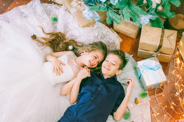 Children Brother Sister Lying Christmas Tree Holiday Dresses Gifts Silver — Stock Photo, Image