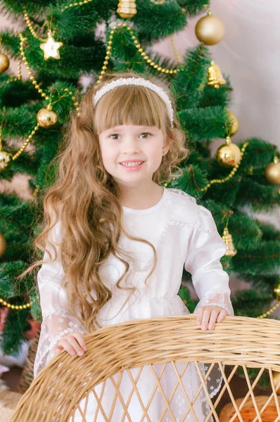 ギフトや銀のコンフェッティと休日のドレスでクリスマスツリーによって白いボールのガウンで長い髪を持つかわいい女の子 クリスマス気分 — ストック写真