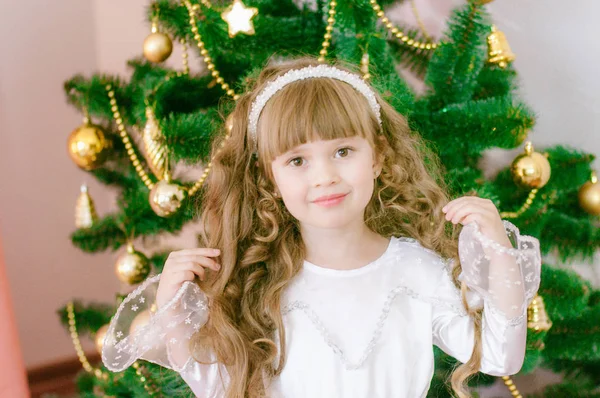 ギフトや銀のコンフェッティと休日のドレスでクリスマスツリーによって白いボールのガウンで長い髪を持つかわいい女の子 クリスマス気分 — ストック写真