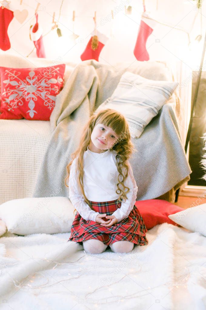 Cute girl with long hair  in the room with Christmas decorations and gifts. Christmas mood