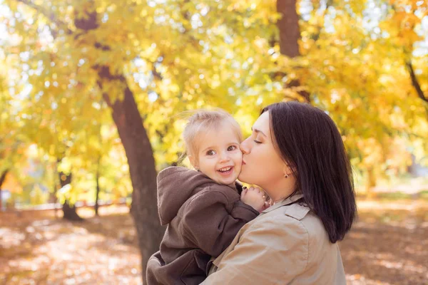 秋天公园里的家人在黄叶间 年轻的母亲带着一个小女儿在秋天的公园里玩树叶 秋天的心情 — 图库照片