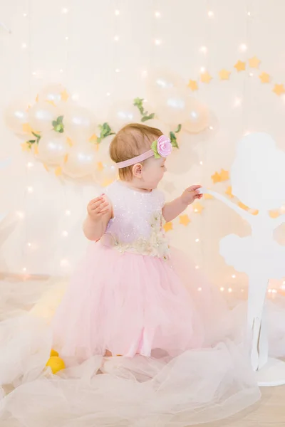 穿着粉色公主礼服 头发上插着花的可爱小女孩 在金星般的星空中与木制芭蕾舞演员嬉戏 背景是一个巨大的白色木制月亮和气球 儿童装饰 — 图库照片