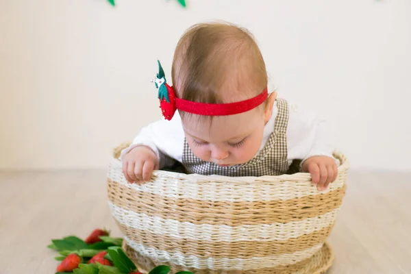 赤いジューシーなイチゴで飾られたウィカーバスケットに小さなかわいい女の子1歳 健康的な食事夏の気分 — ストック写真