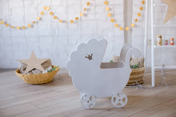 Wooden doll furniture in the room for the little princess. Doll carriage for a little girl. Children\'s furniture. Toys and children\'s furniture