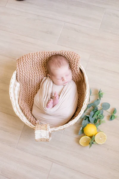 Schattige Kleine Baby Ligt Een Rieten Mandje Versierd Met Groen — Stockfoto