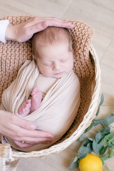 Χέρια Της Μαμάς Κρατούν Μωρό Ξαπλωμένο Ένα Ψάθινο Καλάθι Διακοσμημένο — Φωτογραφία Αρχείου