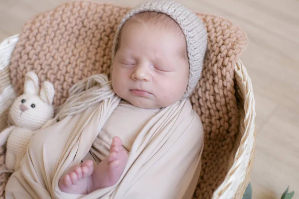 Leuke Kleine Baby Een Gebreide Muts Met Een Speelgoedkonijntje Ligt — Stockfoto