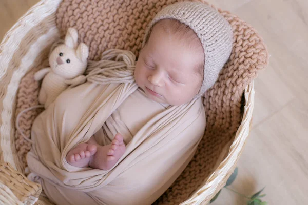 Leuke Kleine Baby Een Gebreide Muts Met Een Speelgoedkonijntje Ligt — Stockfoto