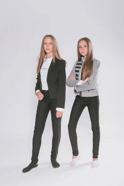 Twee Leuke Meisjes Schoolmeisjes Een Trendy Schooluniform Een Witte Achtergrond — Stockfoto