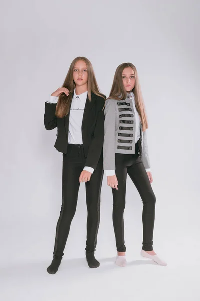 Twee Leuke Meisjes Schoolmeisjes Een Trendy Schooluniform Een Witte Achtergrond — Stockfoto