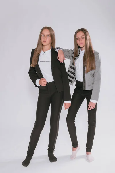 Twee Leuke Meisjes Schoolmeisjes Een Trendy Schooluniform Een Witte Achtergrond — Stockfoto