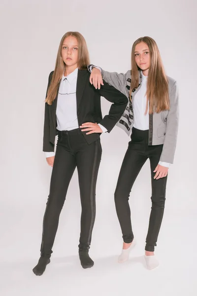 Twee Leuke Meisjes Schoolmeisjes Een Trendy Schooluniform Een Witte Achtergrond — Stockfoto