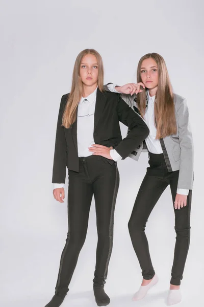 Twee Leuke Meisjes Schoolmeisjes Een Trendy Schooluniform Een Witte Achtergrond — Stockfoto