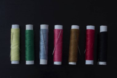 Karanlık bir arka plan iş parçacığında birkaç rengarenk makaralar