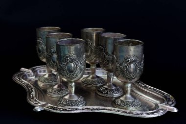 Bir tepsi üzerinde siyah bir arka plan üzerinde gümüş gözlük dizi