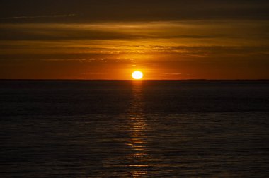 Okyanusun üzerinde ufuk içine büyük güneş batmadan olarak büyük turuncu günbatımı