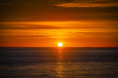 Okyanusun üzerinde ufuk içine büyük güneş batmadan olarak büyük turuncu günbatımı