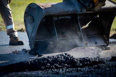 İnşaat alanının üzerine yeni asfalt seriyorlar.