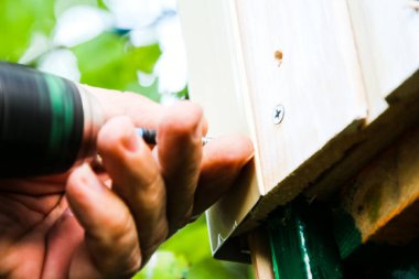 Adamın biri vidayı tornavidayla tahta tahtaya çeviriyor.