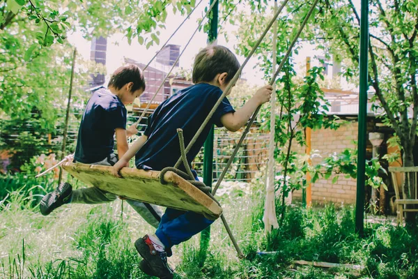 Dos Niños Pequeños Balancean Juntos Columpio Jardín —  Fotos de Stock