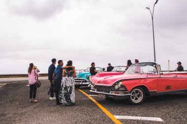 Havana, Küba, Şubat 2020: İnsanlar eski bir eski arabanın yanında duruyor