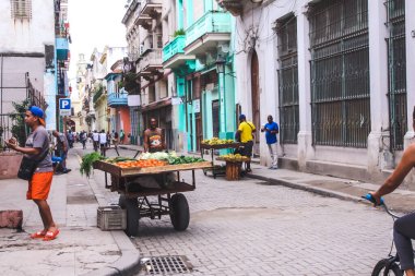 Havana, Küba, Şubat 2020: Siyah satıcı bir el arabasından meyve ve sebze satıyor