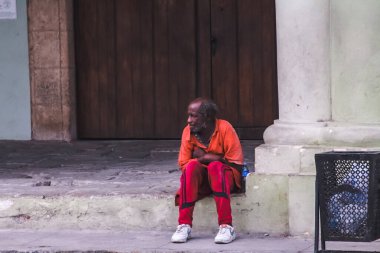 Havana, Küba, Şubat 2020: siyah yaşlı bir adam merdivenlerde oturuyor