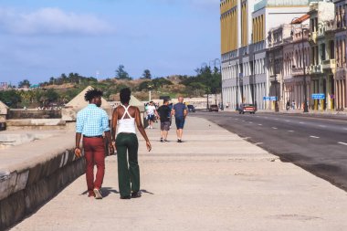 Havana, Küba, Şubat 2020: Malecon kıyı şeridi boyunca yürüyen koyu tenli genç bir çift