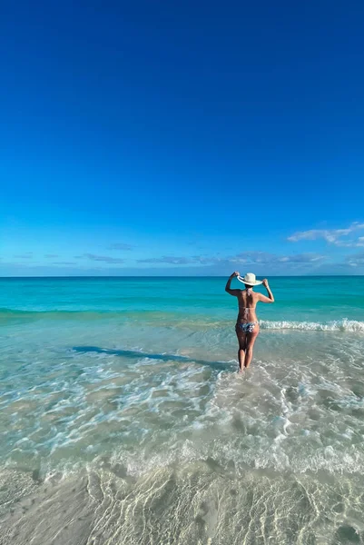 Cayo Santa Maria, Küba, Şubat 2020: Okyanusta bikinili ve parlak şapkalı bir kız