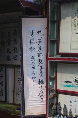 Pekin, Çin, 30 Temmuz 2020: Üzerinde Çin yazıtları bulunan eski baskılar ve tablolar, Lyulichan Pedestrian Caddesi 'ndeki bir antikacının girişinde asılı.